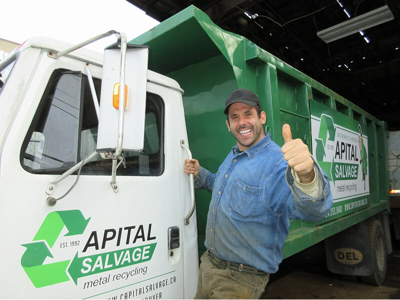 Dov poses with a thumbs-up in front of a truck
